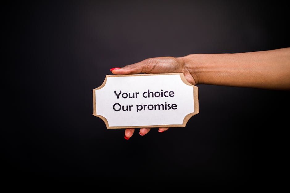 A hand holds a sign saying 'Your choice, Our promise' against a dark background