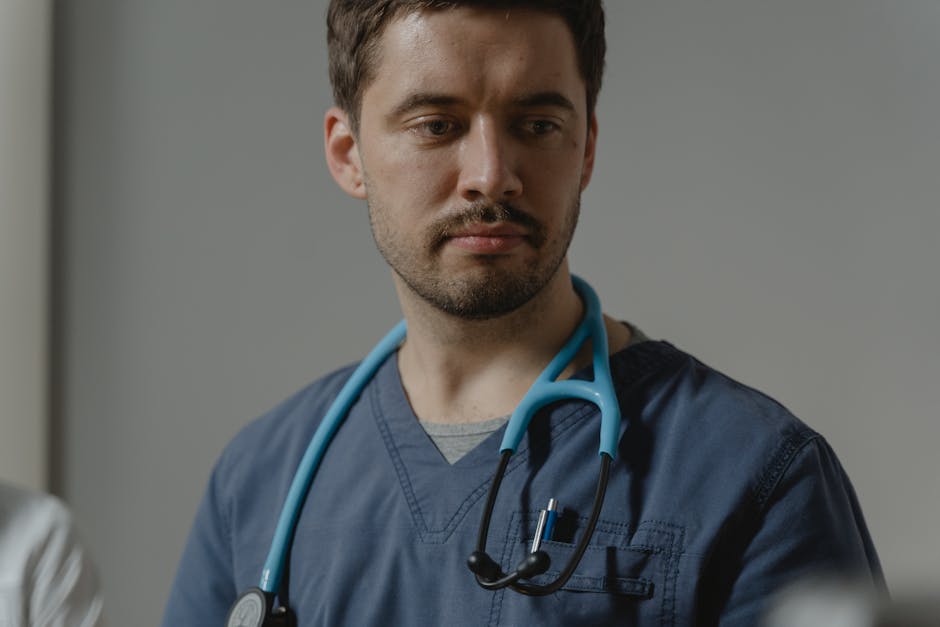 Close-up of a male healthcare worker with stethoscope in a clinical setting.